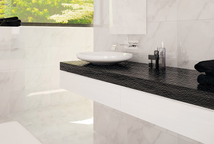 Cubierta de piedra negra con lavabo y muros de piedra blanca